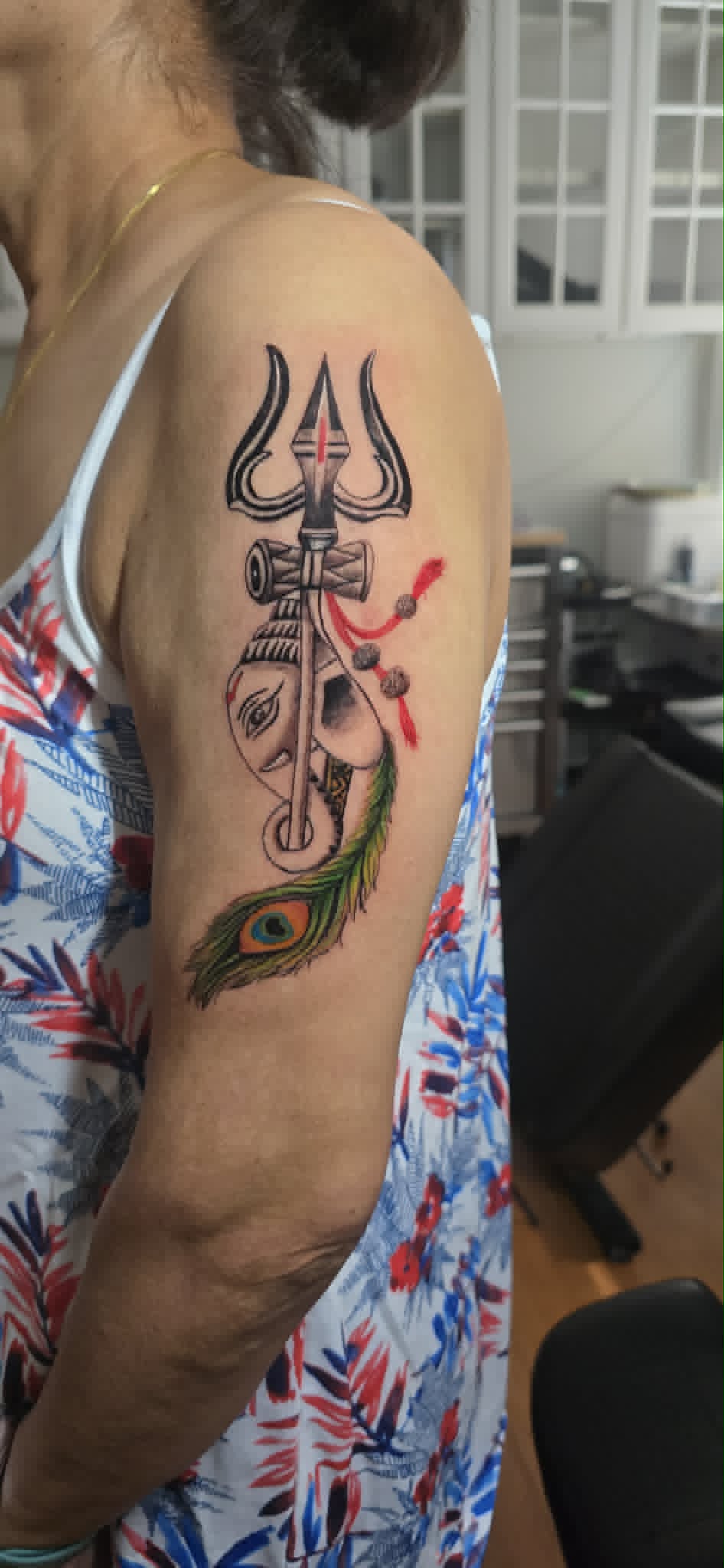 Shiva trishul with Ganesha and peacock feather tattoo