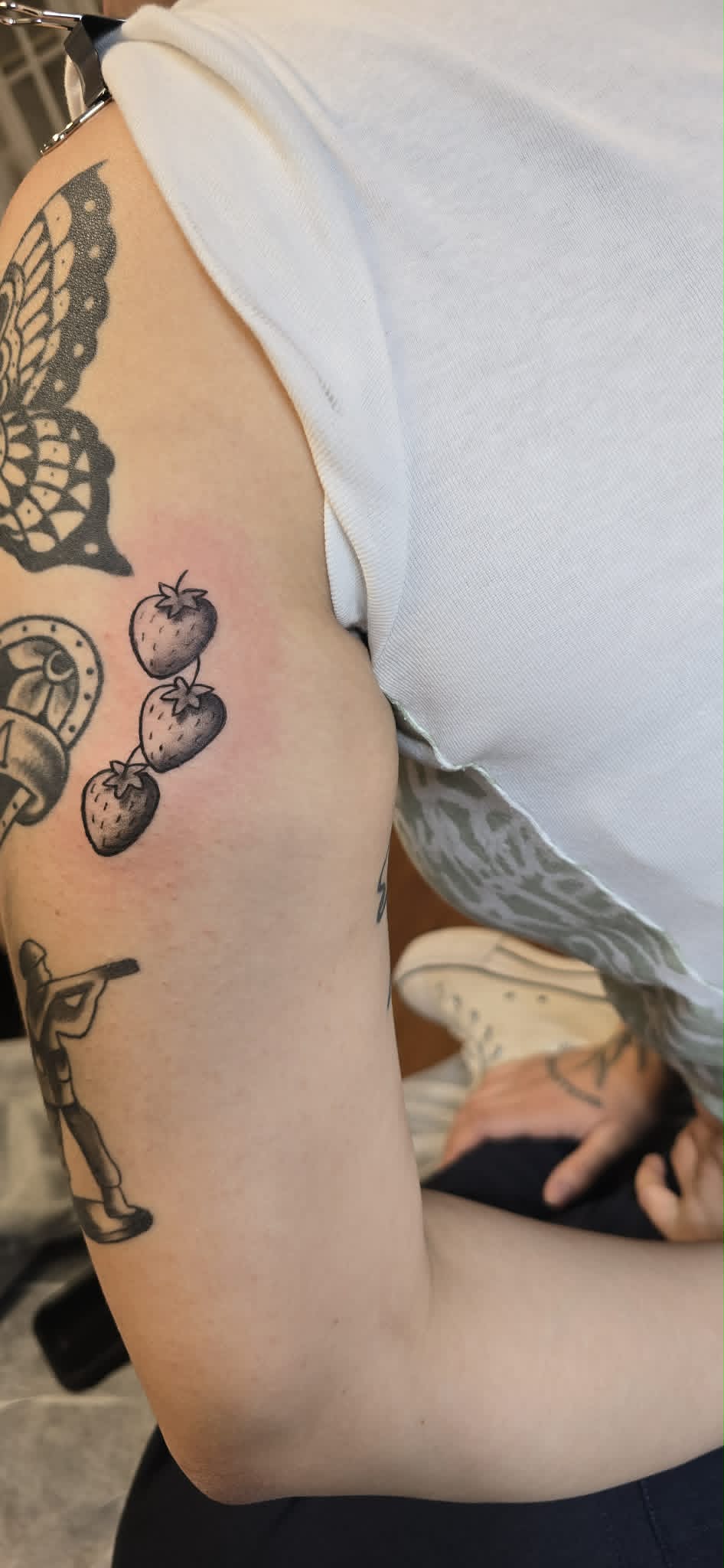 Black and grey strawberry tattoo on arm