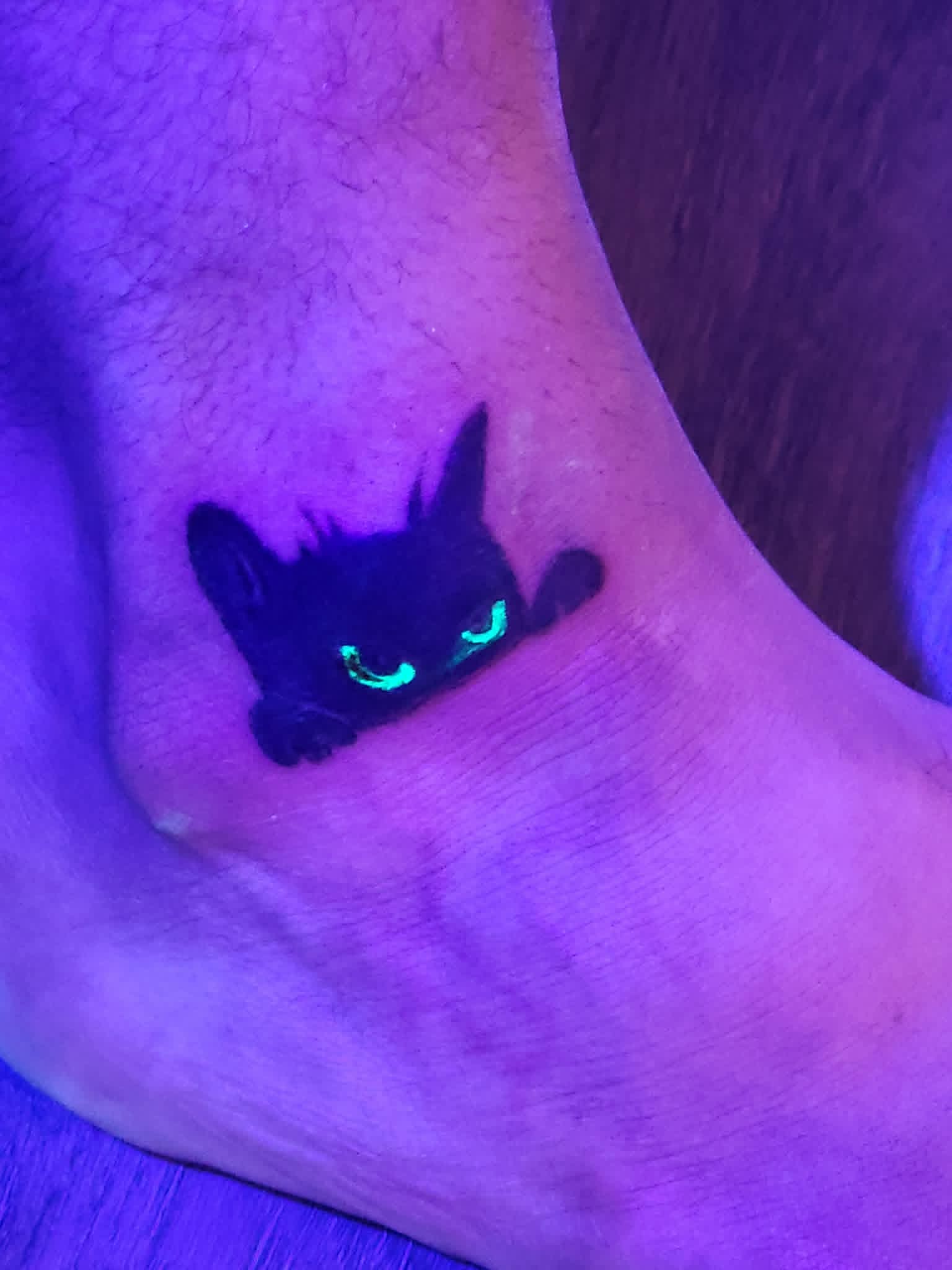 UV blacklight cat tattoo on ankle