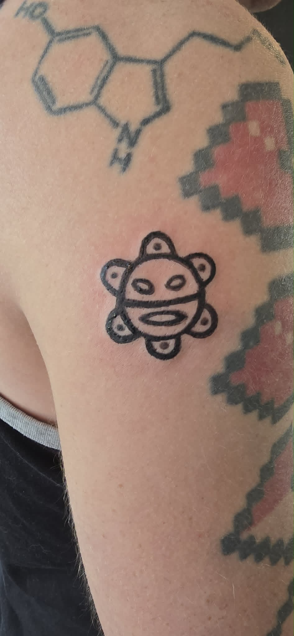 Aztec sun face tattoo on arm